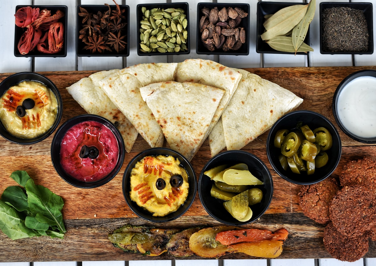 Middle Eastern mezze spread with flatbread, hummus, and pickles on a wooden board
