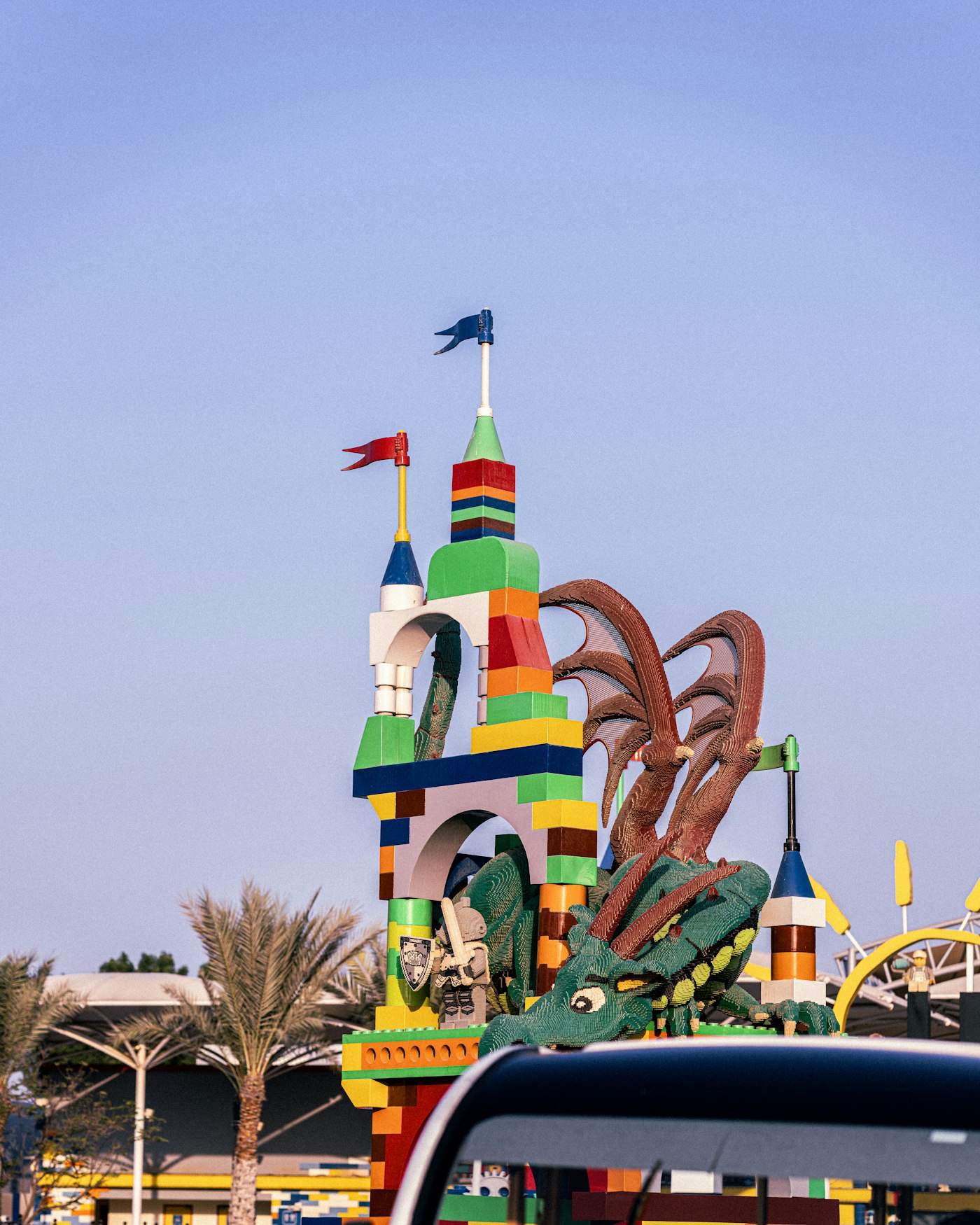 Legoland Dubai castle entrance with colourful Lego brick towers and a Lego dragon under a clear blue sky