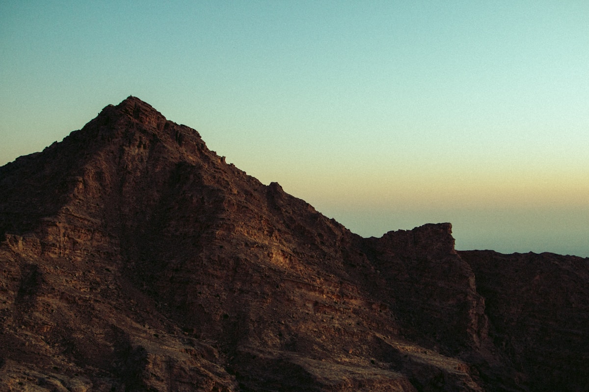 Jagged peak of Jebel Hafeet mountain towering against a gradient sky, Al Ain UAE