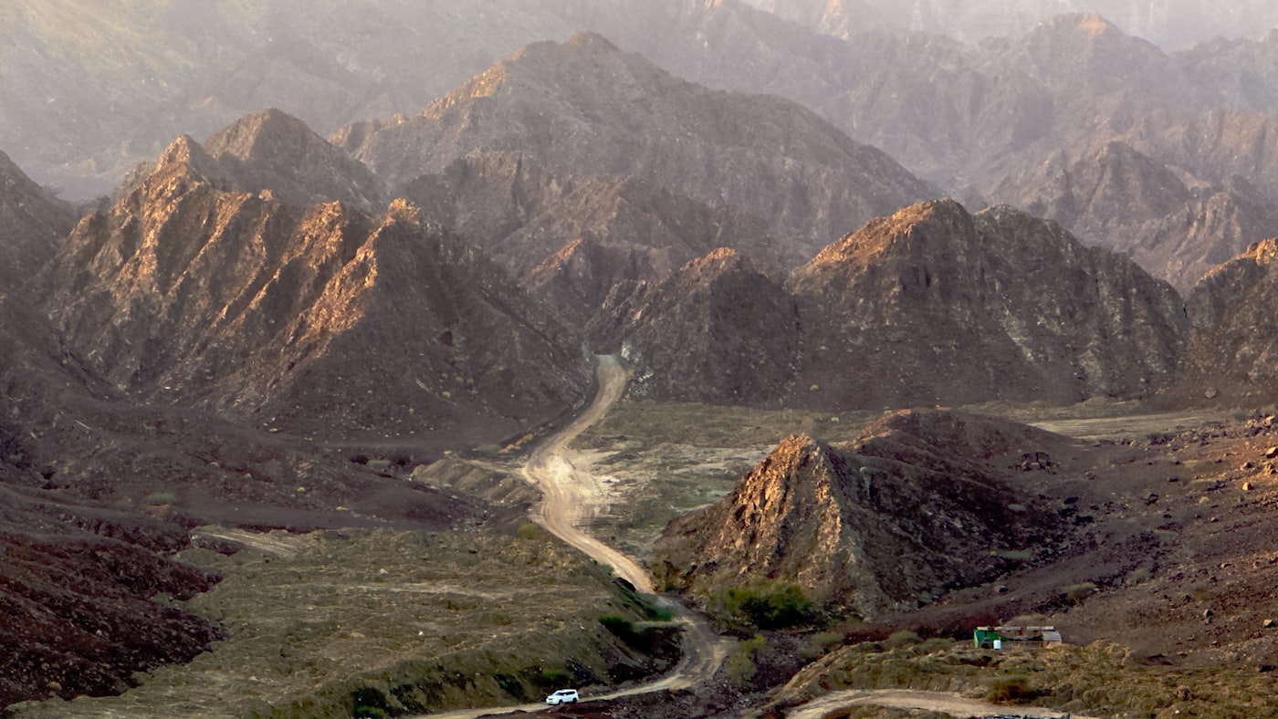 Rugged Hajar Mountains with winding road in Ras Al Khaimah UAE near Jebel Jais