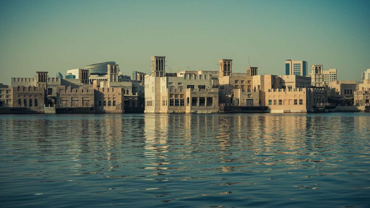 Ajman waterfront and dhow harbour with traditional wooden boats at sunset