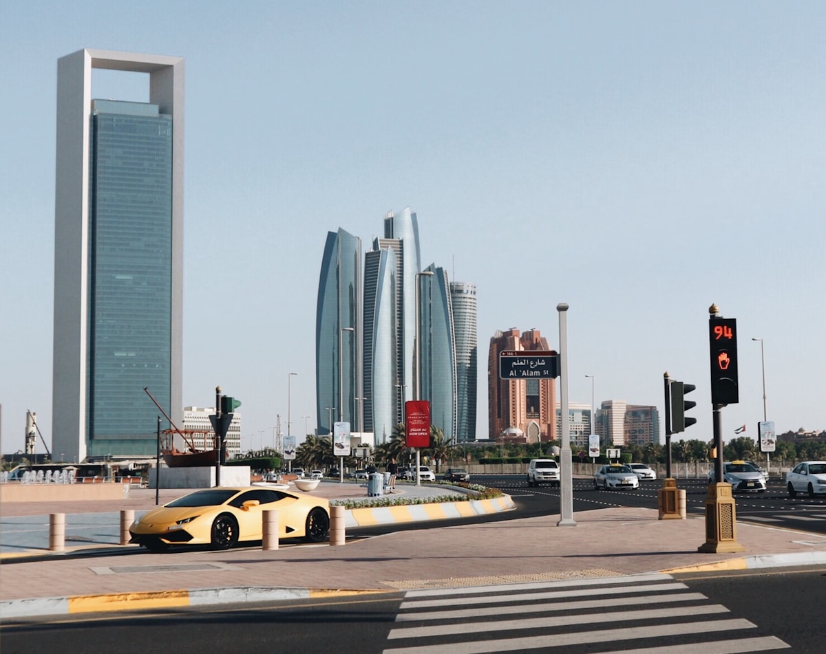 Yellow Lamborghini at Abu Dhabi city road with Etihad Towers skyline in background UAE