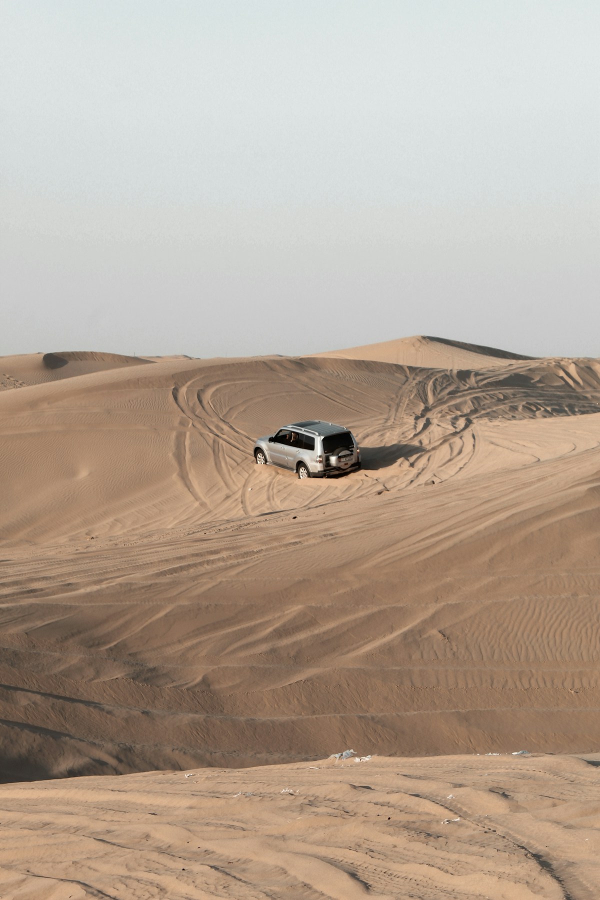 White SUV driving on a desert road in Abu Dhabi, UAE