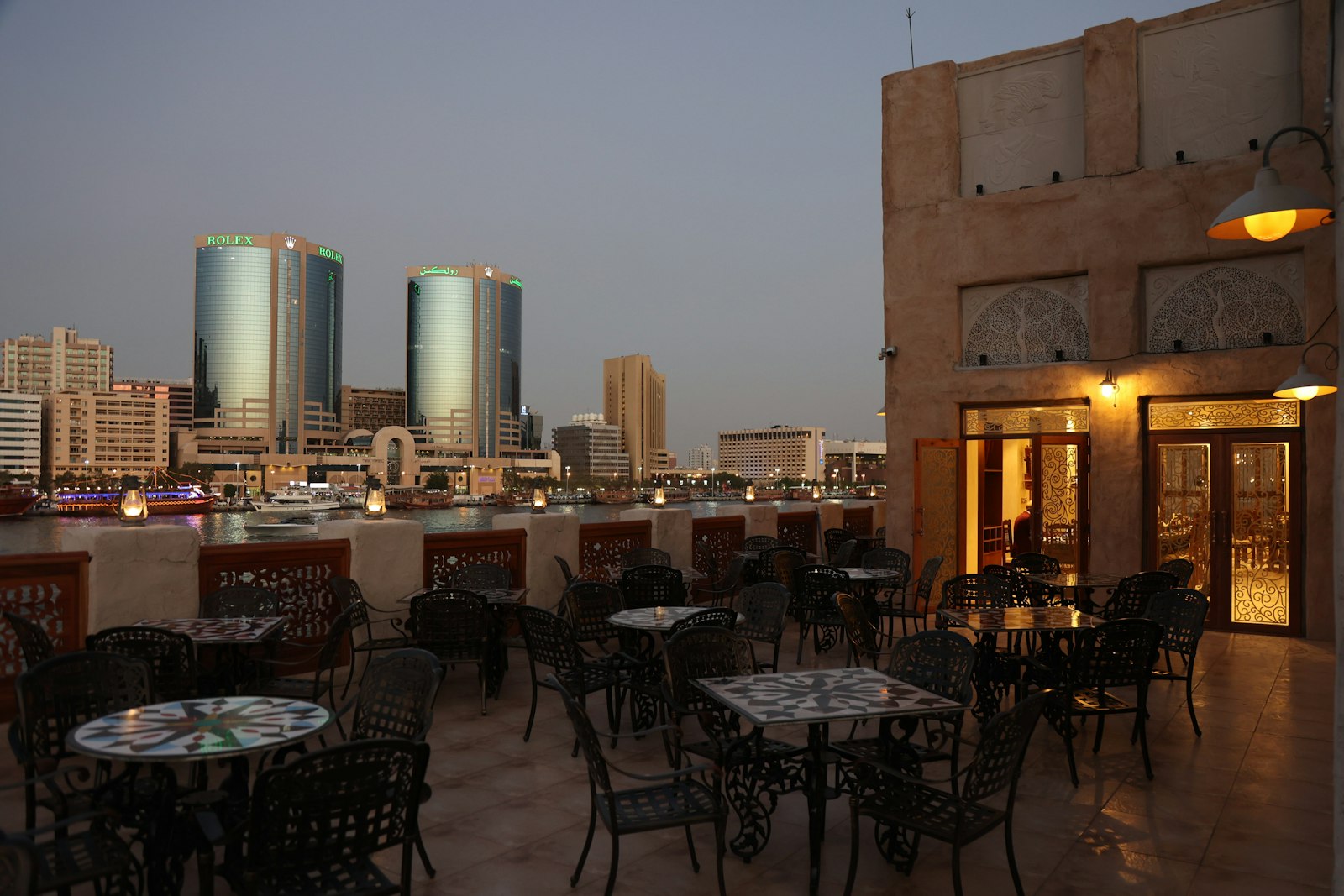 Rooftop terrace restaurant overlooking a waterway at dusk in UAE