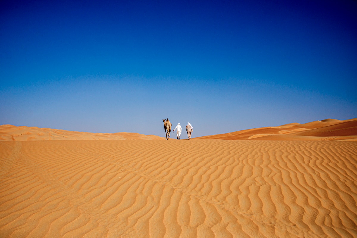 People walking across a desert landscape near Liwa Abu Dhabi UAE
