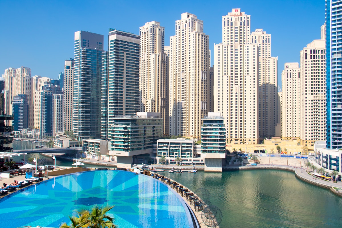 Rooftop pool with glass skyscrapers surrounding it, luxury Dubai UAE