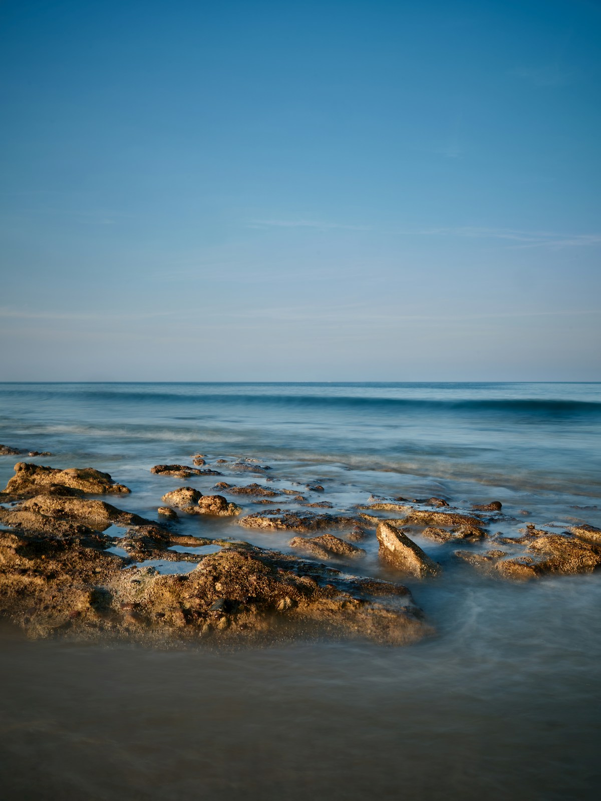 Rocky coastline at Dibba Al Fujairah with calm blue water, UAE