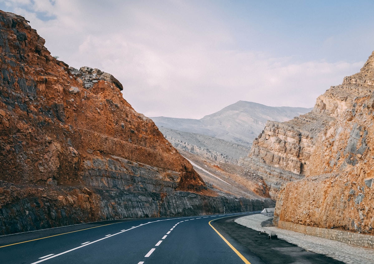 Paved road between brown Hajar mountains at Jebel Jais, Ras Al Khaimah UAE