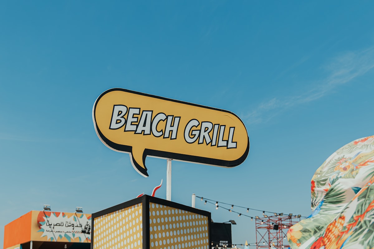 Beach grill sign against blue sky at a UAE beach resort