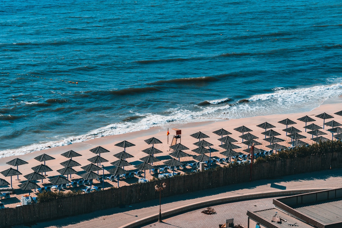 Aerial view of Ajman beach with sun loungers and blue Arabian Gulf water, UAE