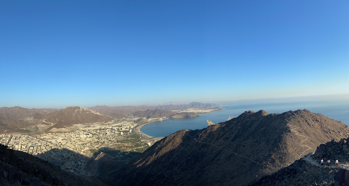 Coastal city of Khor Fakkan with Hajar mountains behind and blue sea in front, UAE east coast