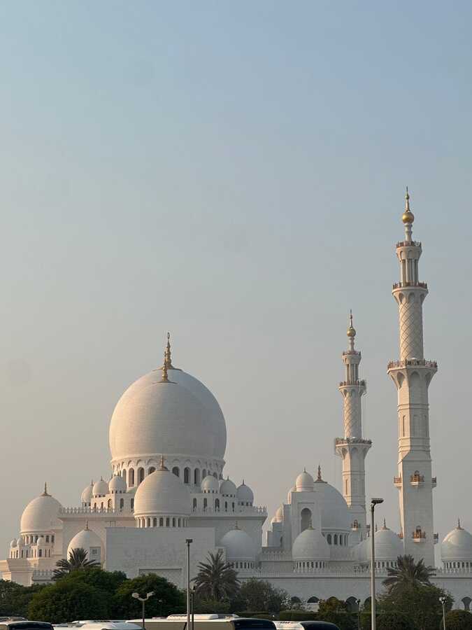 Silhouette of Sheikh Zayed Grand Mosque reflected in water at sunset, Abu Dhabi