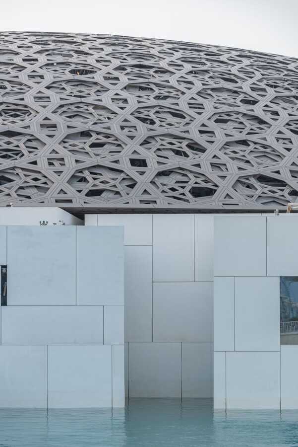 Perforated dome of Louvre Abu Dhabi above the water