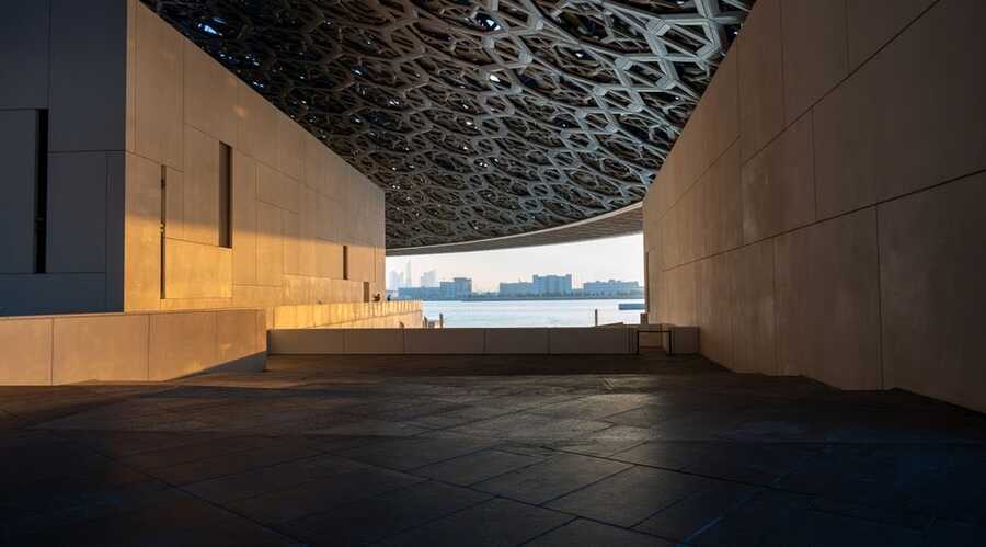 Louvre Abu Dhabi gallery with the perforated dome ceiling and sea view