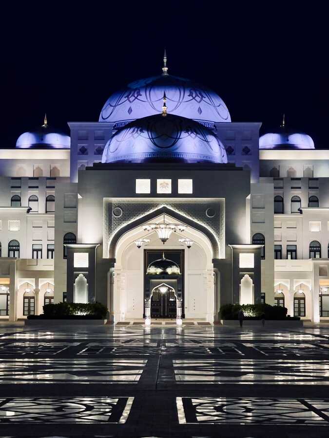 Qasr Al Watan palace lit up at night with white facade and domes