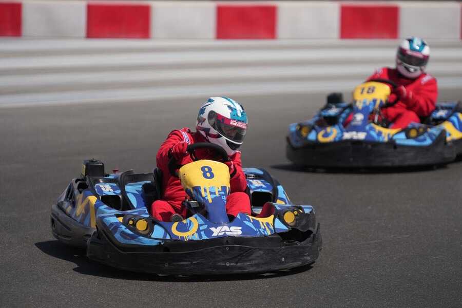 Two drivers in helmets racing go-karts at Yas Marina Circuit