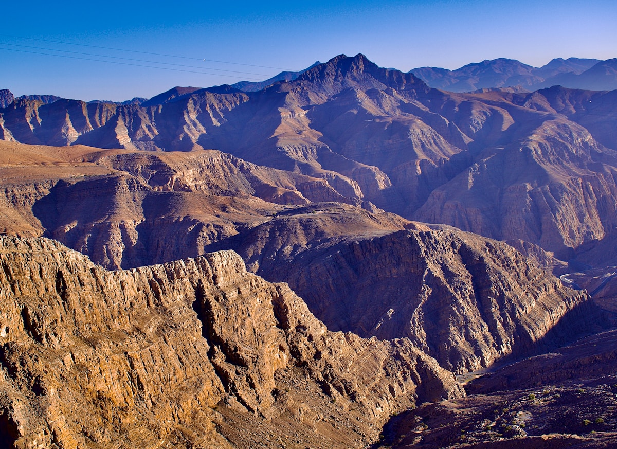 Rugged Jebel Jais mountain ridges under blue sky in Ras Al Khaimah, UAE