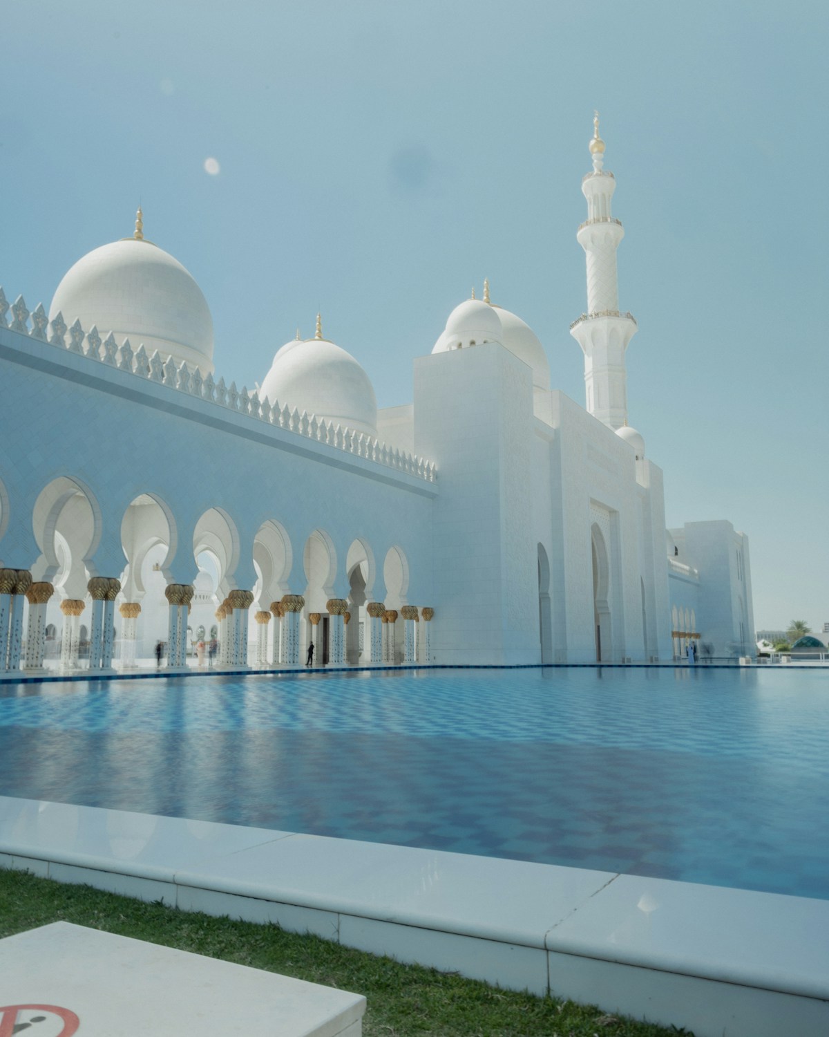 Grand white building with pool reflecting in water, Abu Dhabi UAE luxury