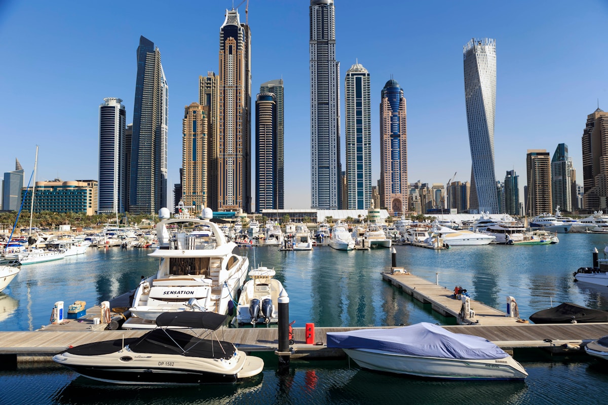 Luxury yachts moored at Dubai Marina with skyscrapers in the background