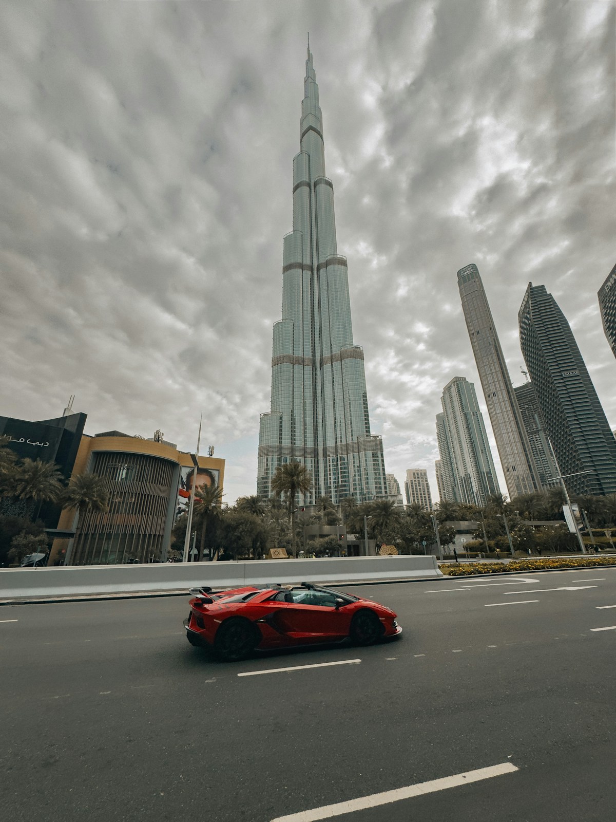 Sports car drives past Burj Khalifa skyscraper Dubai UAE October