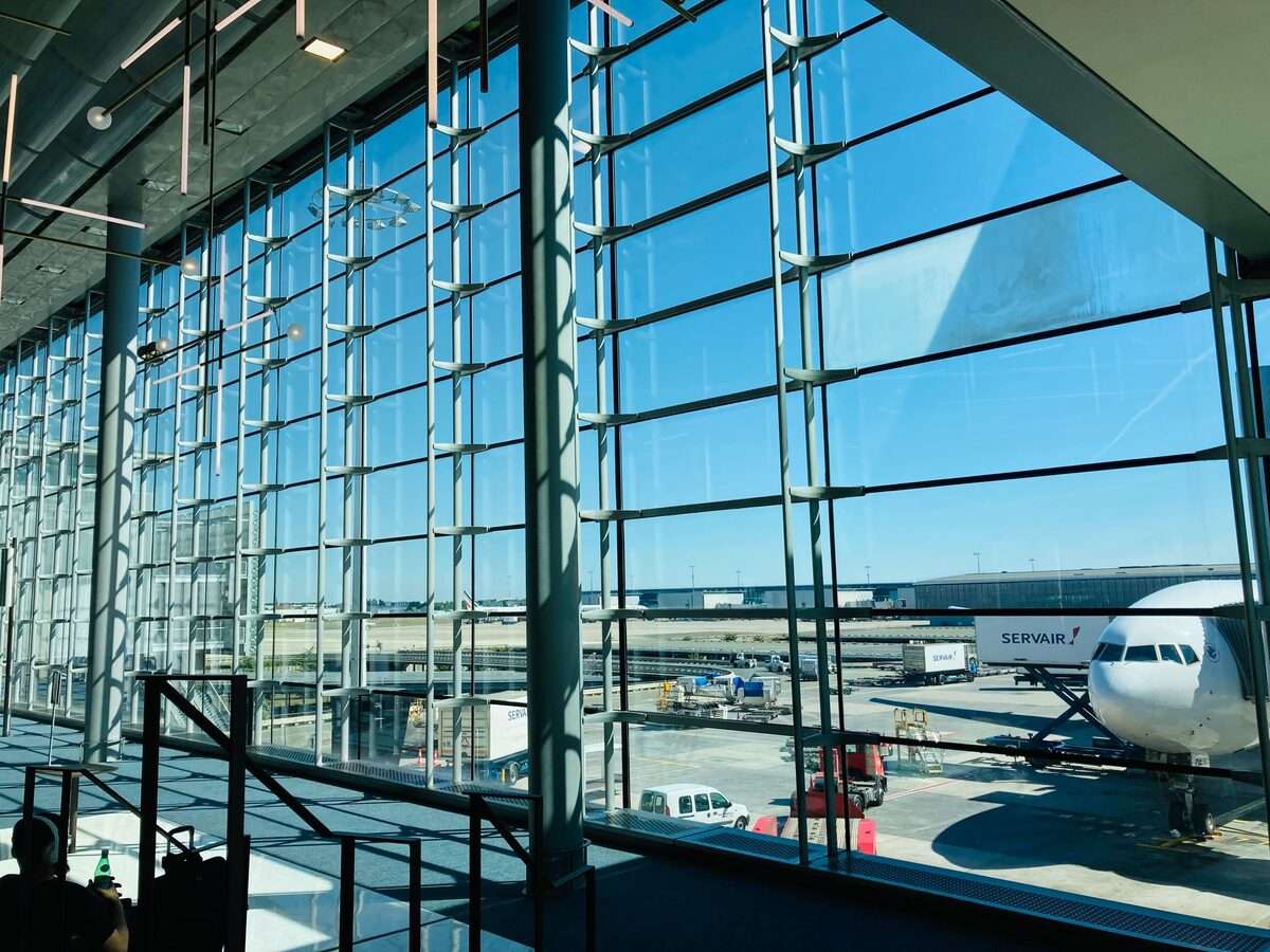 Modern airport terminal interior with large glass panels and aircraft on the tarmac, Dubai International Airport DXB UAE