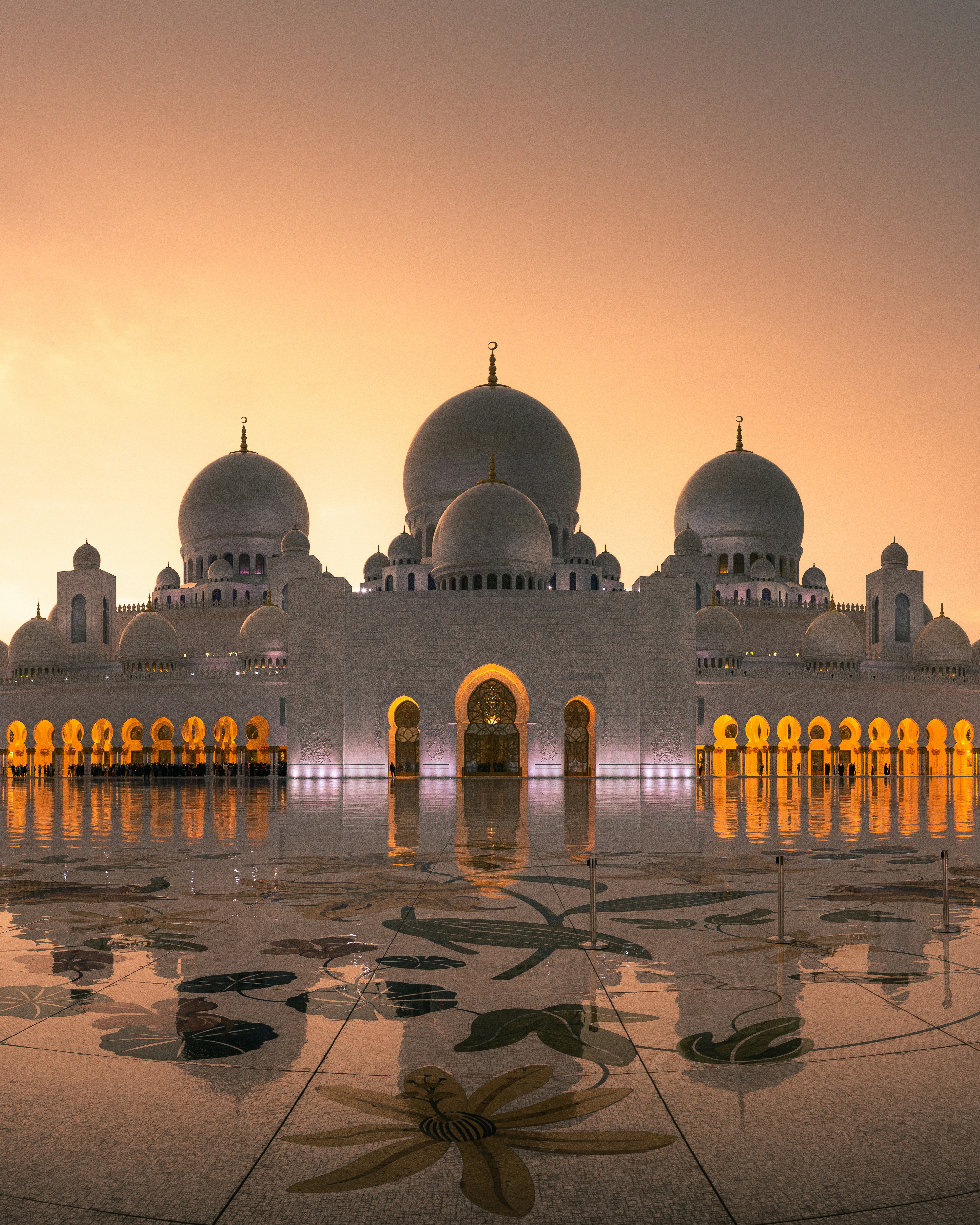Sheikh Zayed Grand Mosque illuminated at sunset in Abu Dhabi, UAE