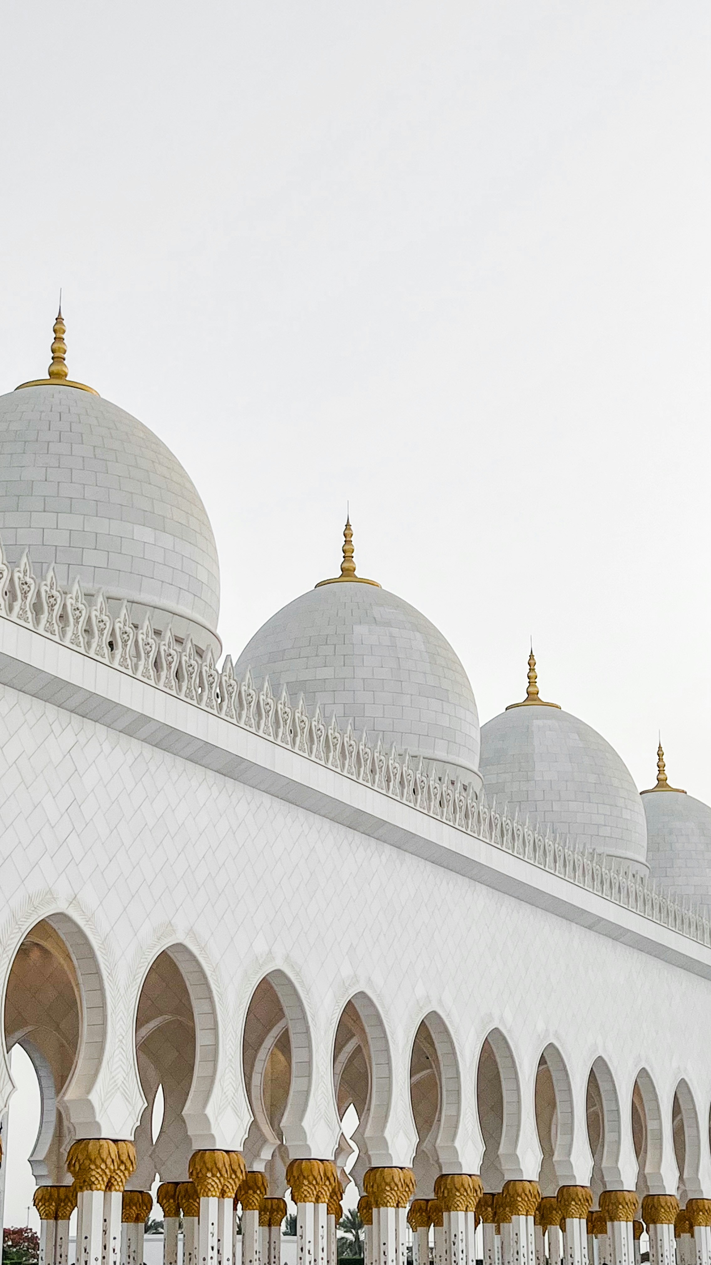 White domes and arched colonnades of Sheikh Zayed Grand Mosque in Abu Dhabi, UAE