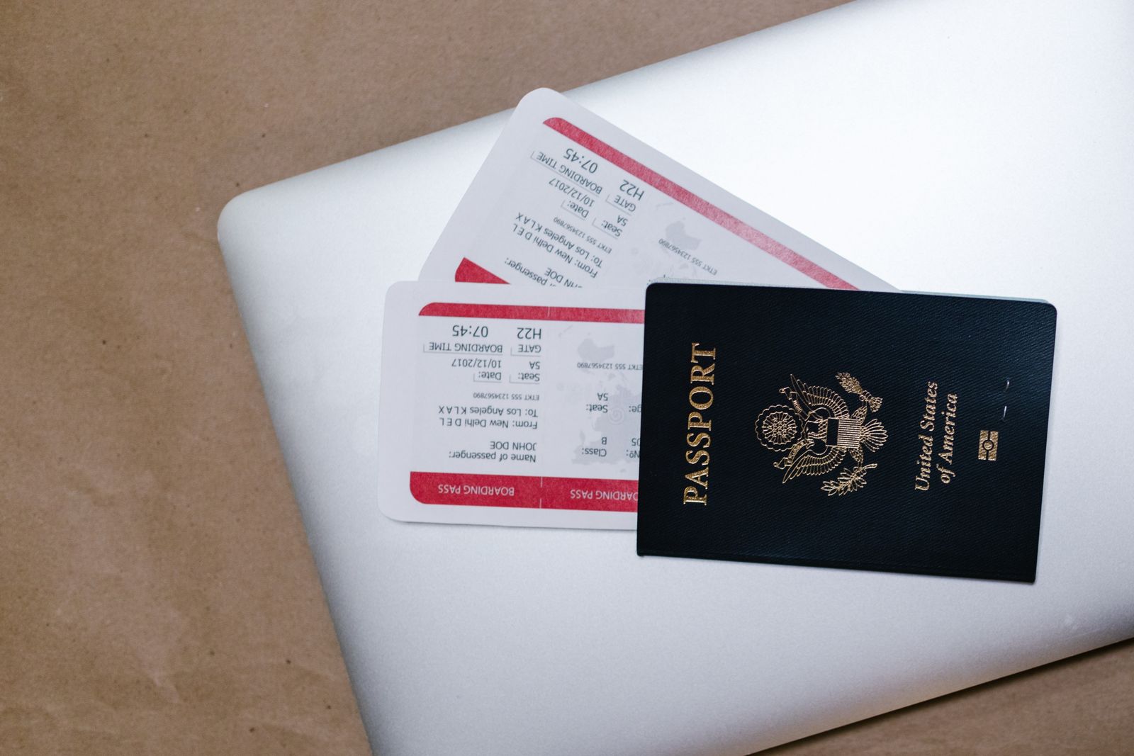 US passport and boarding passes resting on a silver laptop, travel documents for the UAE