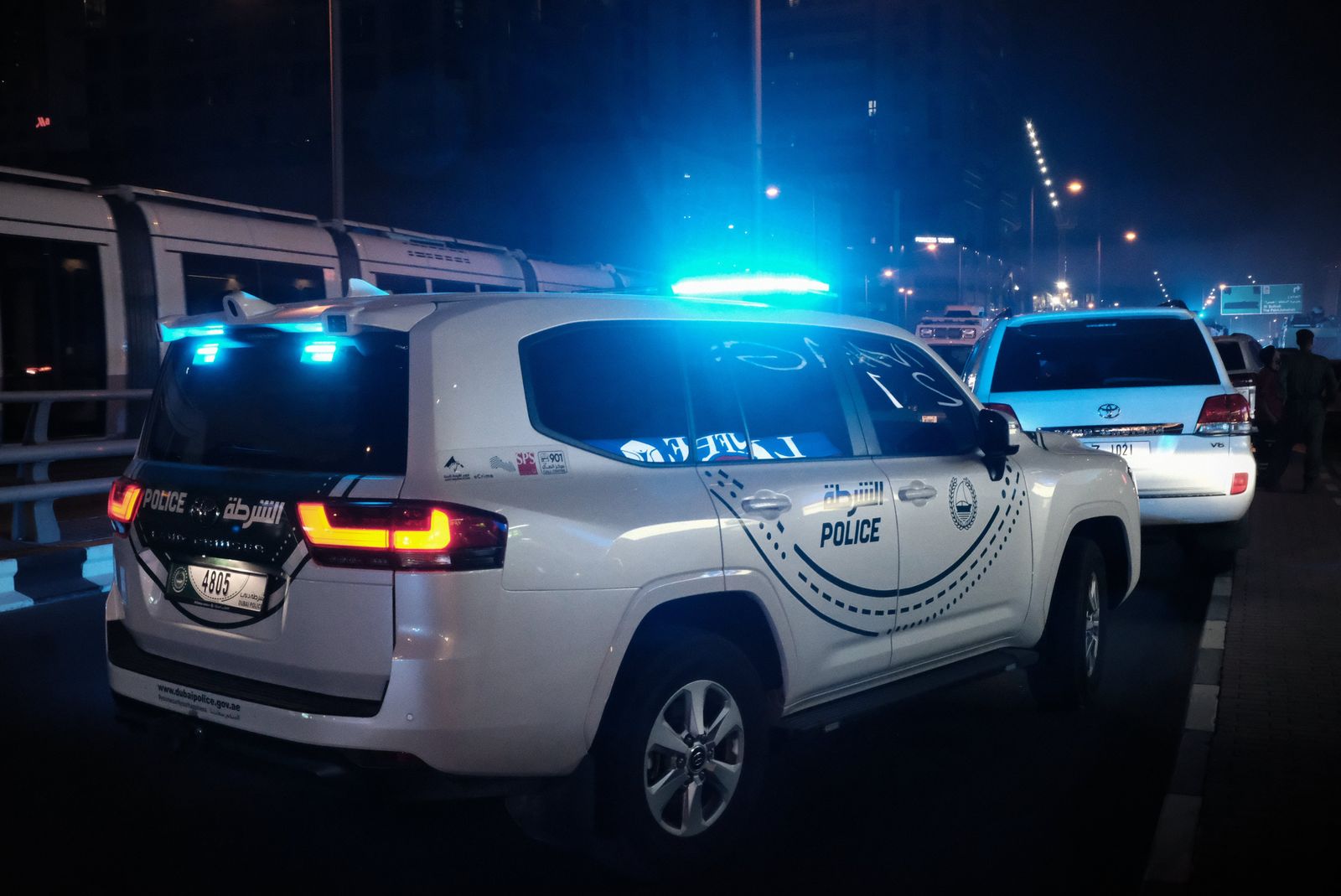 Dubai Police vehicle with flashing blue lights at night in Dubai