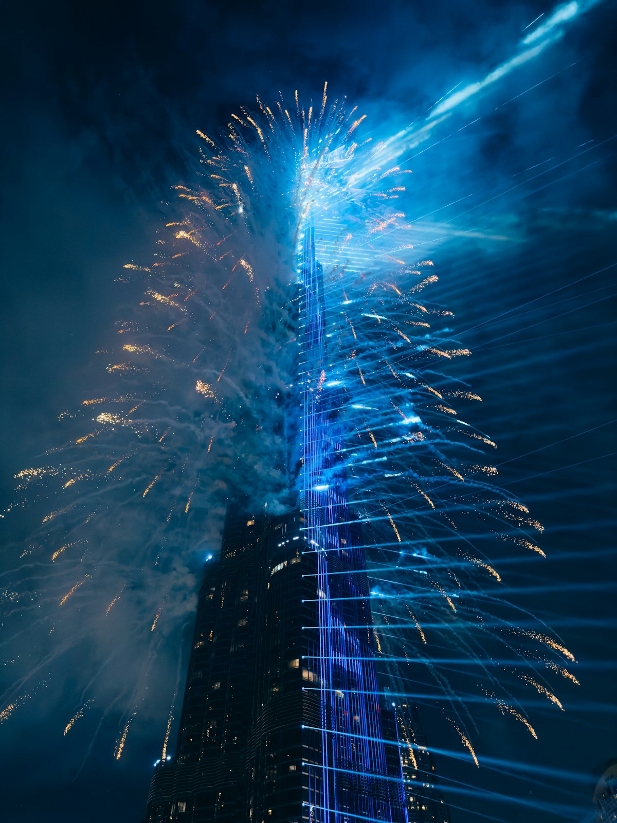 Burj Khalifa with blue laser lights and fireworks at midnight, Dubai UAE