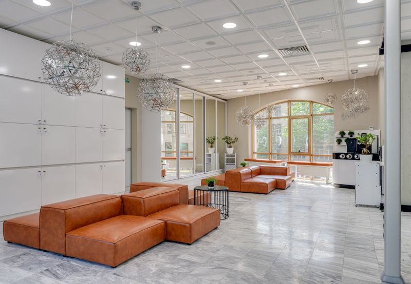 Premium lounge interior with tan leather sofas and designer pendant lighting, airport lounge seating