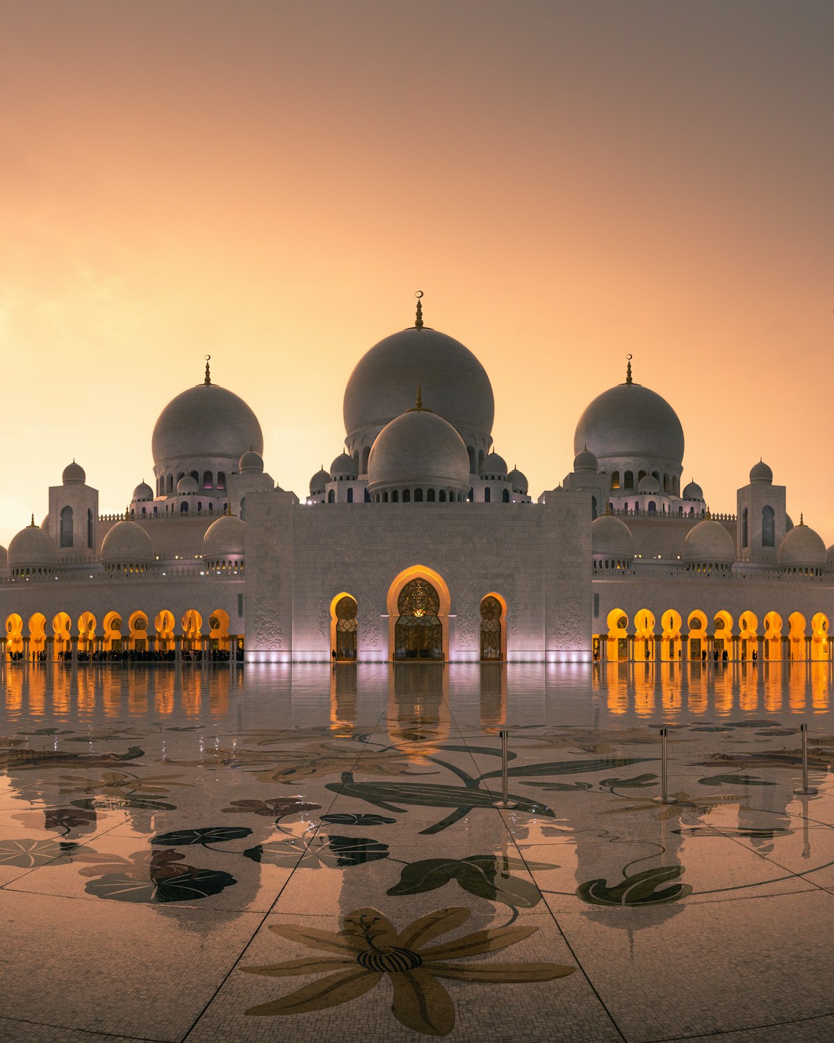 Visitors walking in the courtyard of Sheikh Zayed Grand Mosque, Abu Dhabi UAE