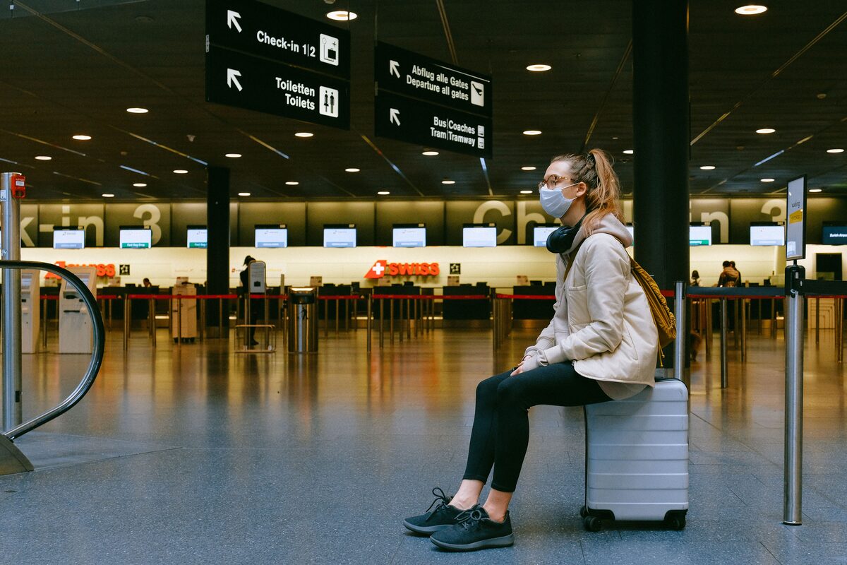 Traveller with suitcase in modern airport terminal, credit card lounge access UAE