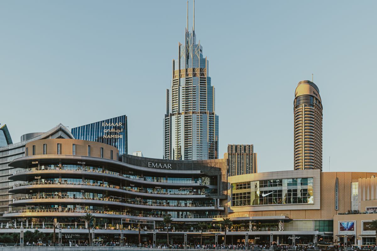 Downtown Dubai towers and mall waterfront under a blue sky