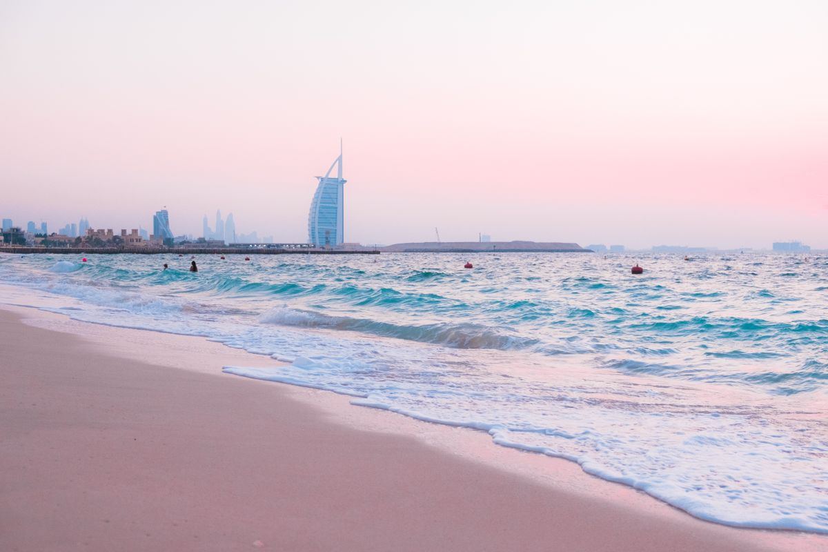 Pink dusk over Jumeirah beach with Burj Al Arab in the distance