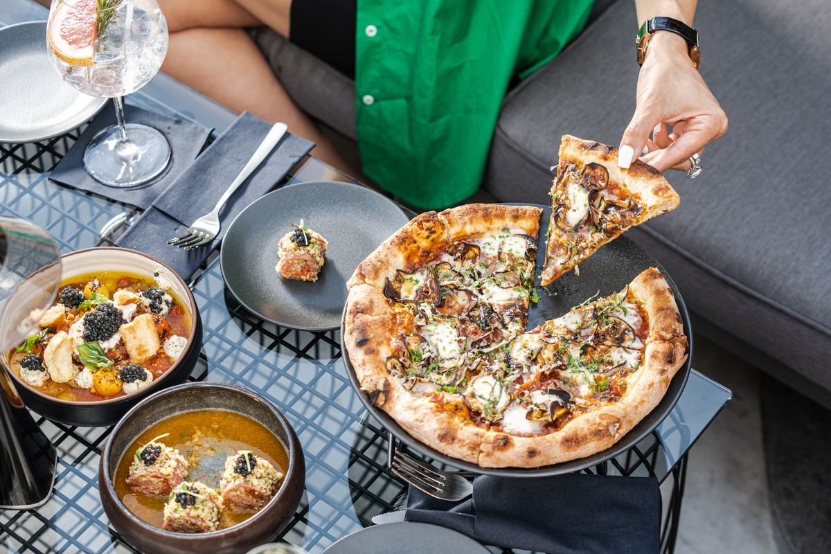 Shared plates and pizza on a table at an upscale Dubai restaurant