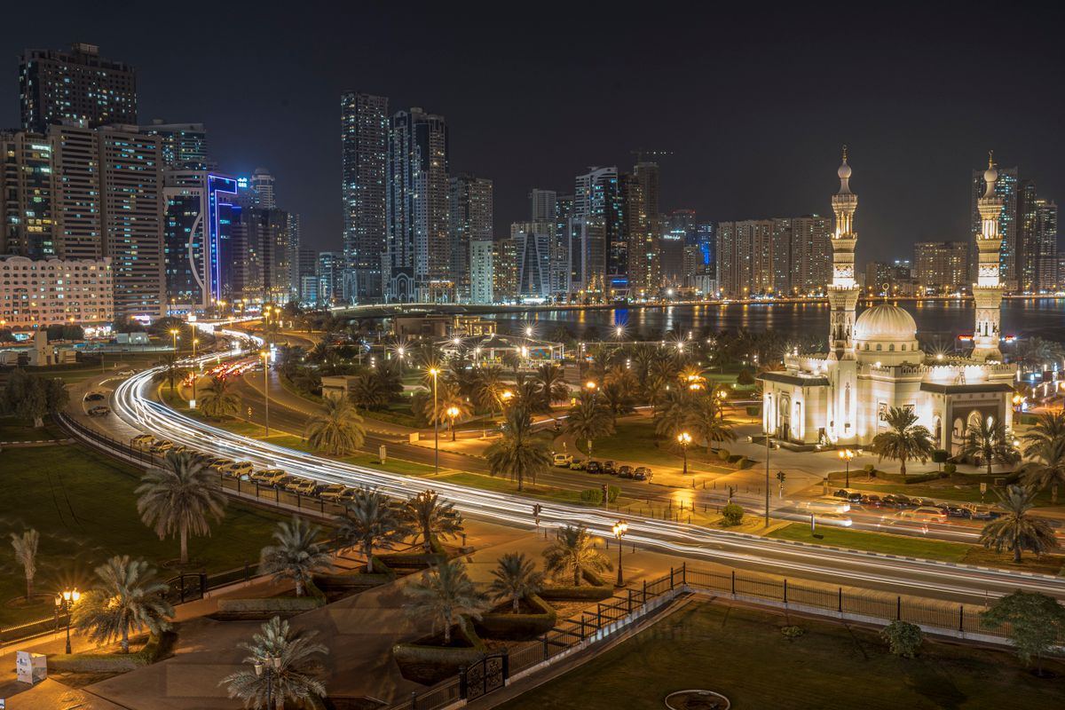 Sharjah city skyline and mosque lit up at night