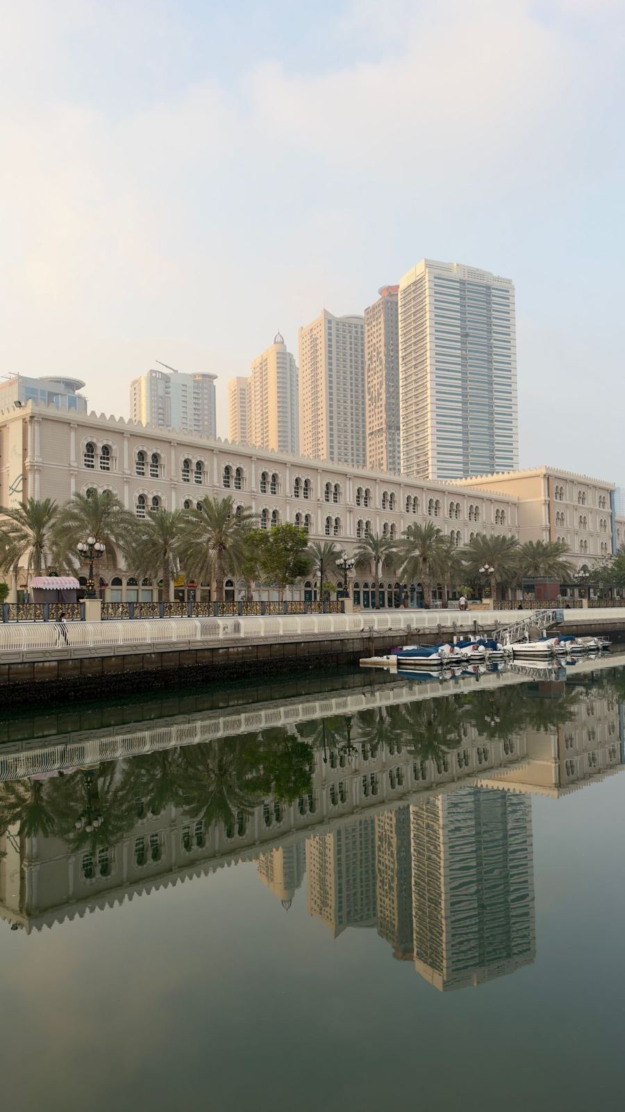 Sharjah waterfront buildings reflected in calm water